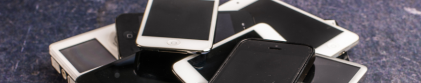 Stack of various smartphones on a textured surface